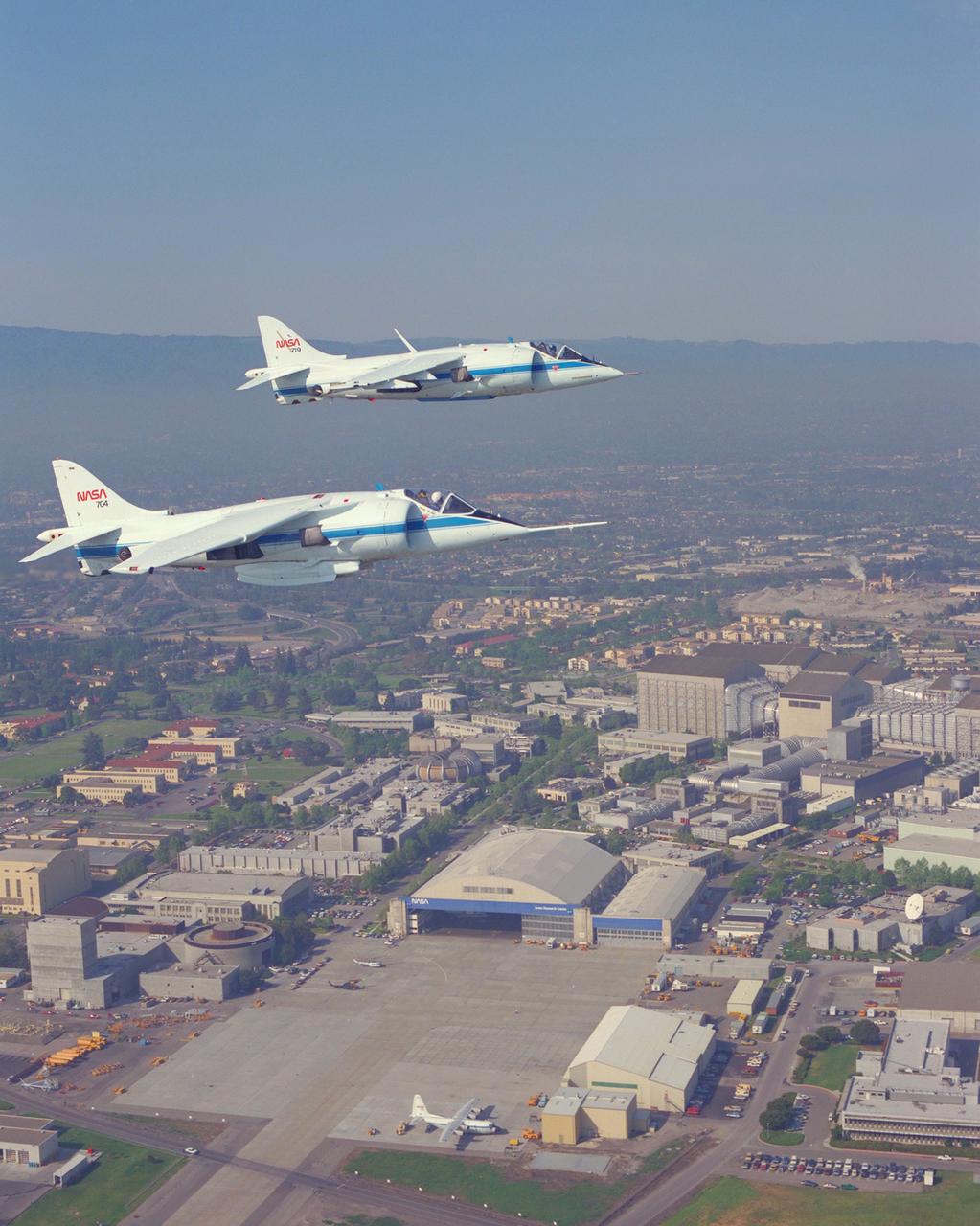 AV-8B (NASA-719) and AV-8C (NASA-704) air to air formation flight  over NASA Ames Research Center, Moffett Field.