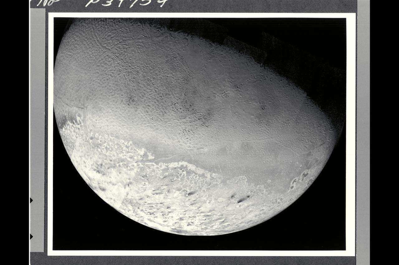 This photomosaic of Triton, assembled from 14 individual frames, shows the great variety of its surface features. At the bottom of the image are remnants of the south polar cap, containing 'dark' streaks generally aligned towards the northeast (upper right in the image). Even though these are darker than other features on Triton, they reflect nearly ten times as much light as the surface of the Earth's moon. North of the cap, in the western (left) half of the disk is the region which has been informally dubbed the 'cantaloupe' terrain. Small dimples with upraised rims and shallow central depressions dot the area. Long fractures have opened allowing some icy material to ooze up and form a central ridge. These criss-cross the region and extend into parts of the polar cap region. Towards the south this terrain has a light covering of frost. Running east to the limb of Triton, just north of the polar cap, is an area of smooth plains and low hills which is the most densely cratered region seen. In the northeast (upper right) of this image are plains which show evidence for extensive resurfacing, including possible extrusions of flowing material onto the surface. This region also contains two large smooth areas reminiscent of the maria of the Earth's moon which were formed by large-scale volcanic flooding. Near the eastern (right) limb of Triton are three darker gray markings with sharply defined brighter borders. These are unlike anything else seen in the solar system, and their origin is not yet understood.