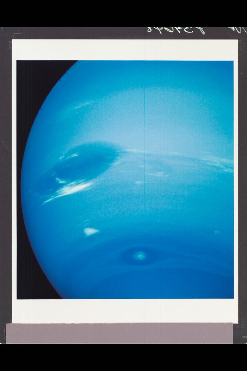 P-34648 This photograph of Neptune was reconstructed from two images taken by Voyager 2's narrow angle camera, through the green and clear filters. the image shows three of the features that Voyager 2 has been photographing during recent weeks. At the north ( top ) is the Great Dark Spot, accompanied by bright, white clouds that undergo rapid changes in appearance. to the south of the Great Dark Spot is the bright feature that Voyager scientists have nicknamed 'Scooter.' Still farther south is the feature called  ' Dark Spot 2,' which has a bright core. Each feature moves  eastward at a  different at a different velocity, so it is only occasionally that they appear close to each other, such as at the time this picture was taken.