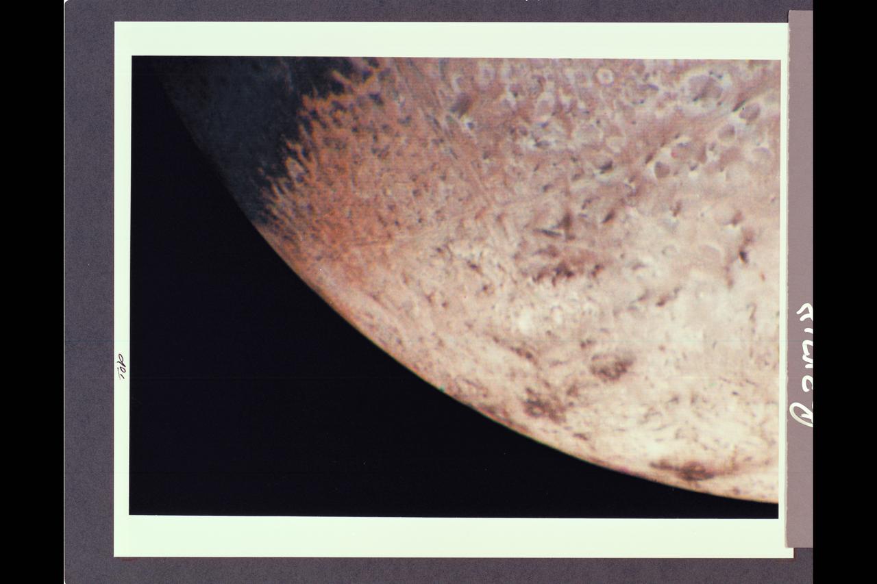 P-34718 Range: 210,000 kilometers (128,000 miles) This natural color image of the limb of Triton shows the largest surface features at about 3 miles across. The picture is a composite of images taken through the violet, green and clear filters and shows a geologic boundary between a rough, pitted surface to the right and a smoother surface to the left. The change between surface types is gradual. The image also shows a color boundary between pinkish material in the upper part of the image and whiter material in the lower part. The geologic and color boundaries are not the same. That implies that whatever supplies the color is a very thin coating over a different underlying material in which the geologic boundary occurs. The colored coating may be a seasonal frost composed of compounds volatile enough to be sublimated at the very low temperatures (40 K to 50 K or -387.4 F to -369.4 F) prevailing near Triton's surface. Possible compositions of the frost layer include methane (which turns red when irradiated), carbon monoxide or nitrogen. The color in this image is somewhat exaggerated: Triton is primarily a white object with a pinkish cast in some areas.