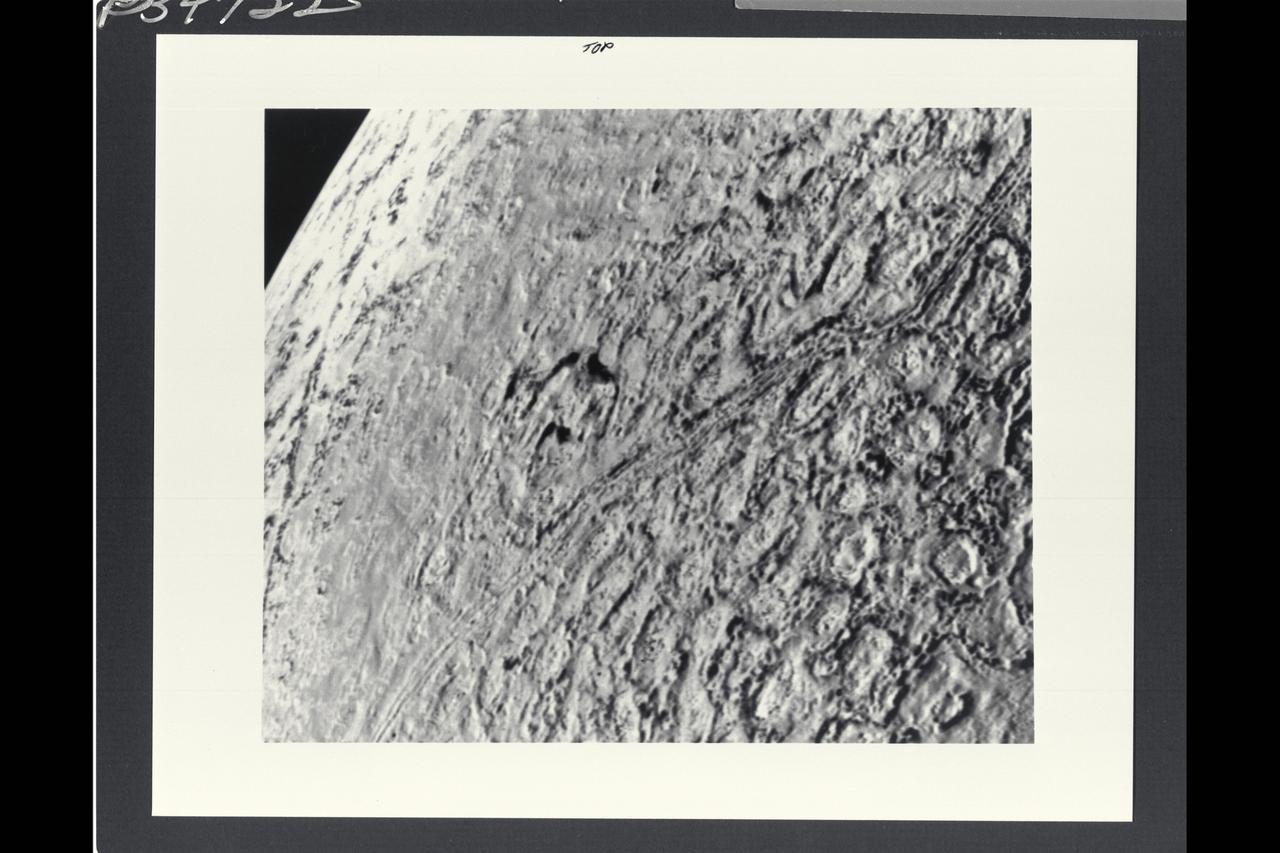 Voyager II Imagery, Neptune: This is one of the most detailed views of the surface of Triton taken by Voyager 2 on its flyby of the large satellite of Neptune early in the morning of August 25, 1989. The picture was stored on the tape recorder and relayed to Earth later. Taken from a distanT ce of only 40,000 km (25, 000 miles), the frame is about 220 kilometers (140 miles) across and shows details as small as 750 meters (0.5 miles). Most of the area is covered by a peculiar landscape of roughly circular depressions separated by rugged ridges. This type of terrain, which covers large tracts of Triton's northern hemisphere, is unlike anything seen elsewhere in the solar system. The depressions are probably not impact craters: They are too similar in size and too regularly spaced. Their origin is still unknown, but may involve local melting and collapse of the icy surface. A conspicuous set of grooves and ridges cuts across the landscape, indicating fracturing and deformation of Triton's surface. The rarity of impact craters suggests a young surface by solar-system standards, probably less than a few billion years old. The Voyager Mission is conducted by JPL for NASA's Office of Space Science and Applications. (JPL ref: P-34722 Voyager N-60 )