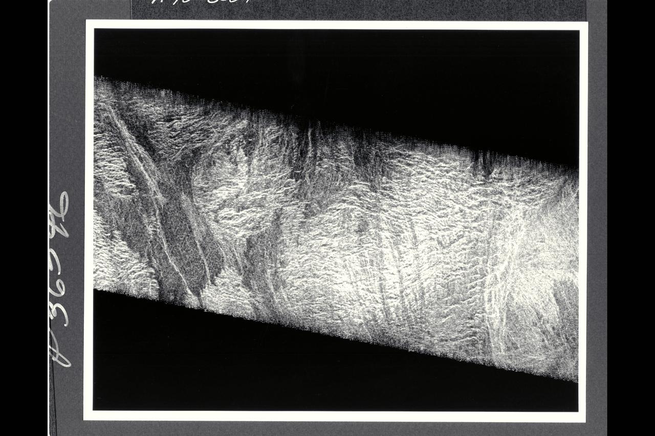 Two mosaicked pieces of Magellan image strips display the area east of the Rhea Mons volcano on Venus. This image is centered at about 32.5 degrees north latitude and 286.6 degrees east longitude. The mosaic is 47 km (28 mi.) wide and 135 km (81 mi.) long. This region has been previously identified as 'tessera'from Earth-based radar (Arecibo) images. The center of the image is dominated by a network of intersection ridges and valleys. The radar-bright north-south trending features in this image range from 1 km (0.6 mi.) to 3 km (1.8 mi.) in length. The average spacing between these ridges is about 1.5 km (0.9 mi.). The dark patches at the top of the image are smooth surfaces and may be lava flows located in lowlands between the higher ridge and the valley terrain. This image is a mosaic of two orbits obtained in the first Magellan stations near Goldstone, CA and Canberra, Australia. The resolution of this image is approx. 120 meters (400 feet).