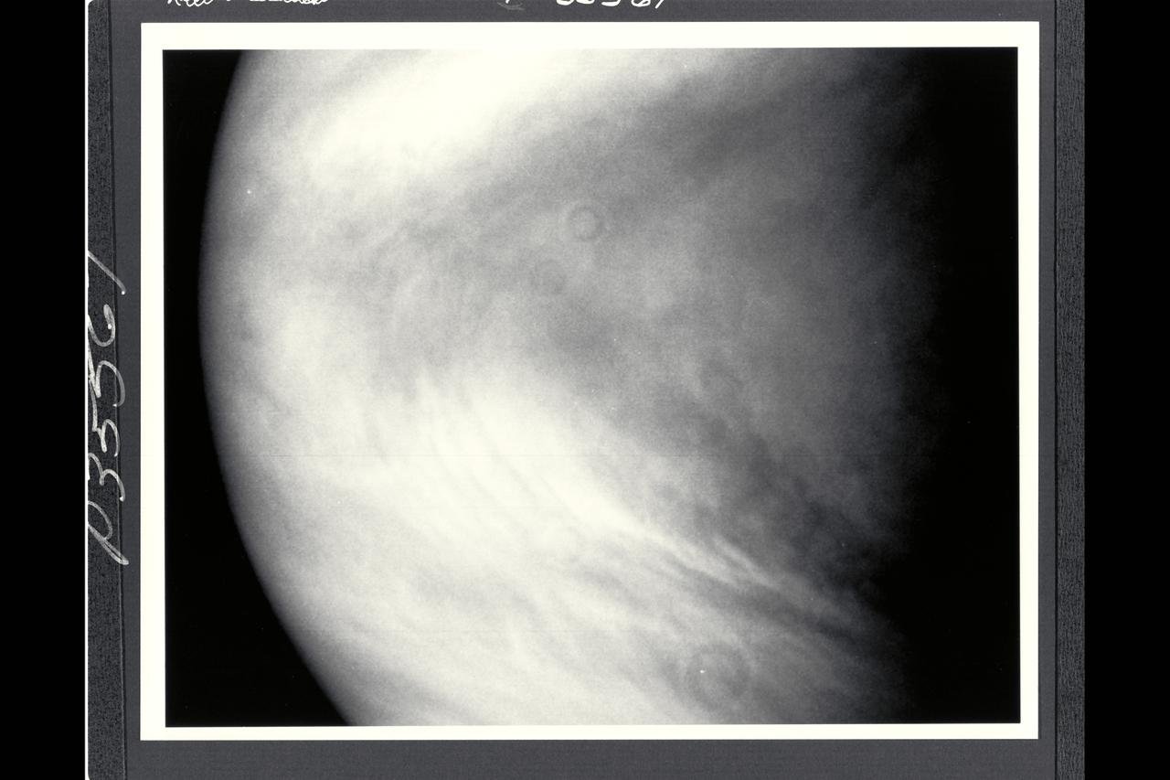 Range : 1 million miles (1.63 million km) This image of the planet Venus was taken by NASA's Galileo spacecraft shortly befor 10pm PST when the space craft was directly above Venus' equator. This is the 66th of more than 80 Venus images Galileo was programmed to take and record during its Venus flyby. In the picture, cloud features as small as 25 miles (40 km) can be seen. Patches of waves and convective clouds are superimpposed on the swirl of the planet's broad weather patterns, marked by the dark chevron at the center. North is at the top. The several ring-shaped shadows are blemishes, not planetary features. The spacecraft imaging system has a 1500-mm, f/8.5 reflecting telescope; the exposure time was 1/40 second. The image was taken through the violet filter (0.41 micron.). It was produced by the imaging system in digital form, as a set of numbers representing the brightness perceived in each of the 640,000 picture elements defined on the solid-state plate, called a charged-coupled-device or CCD, on which the image was focused.