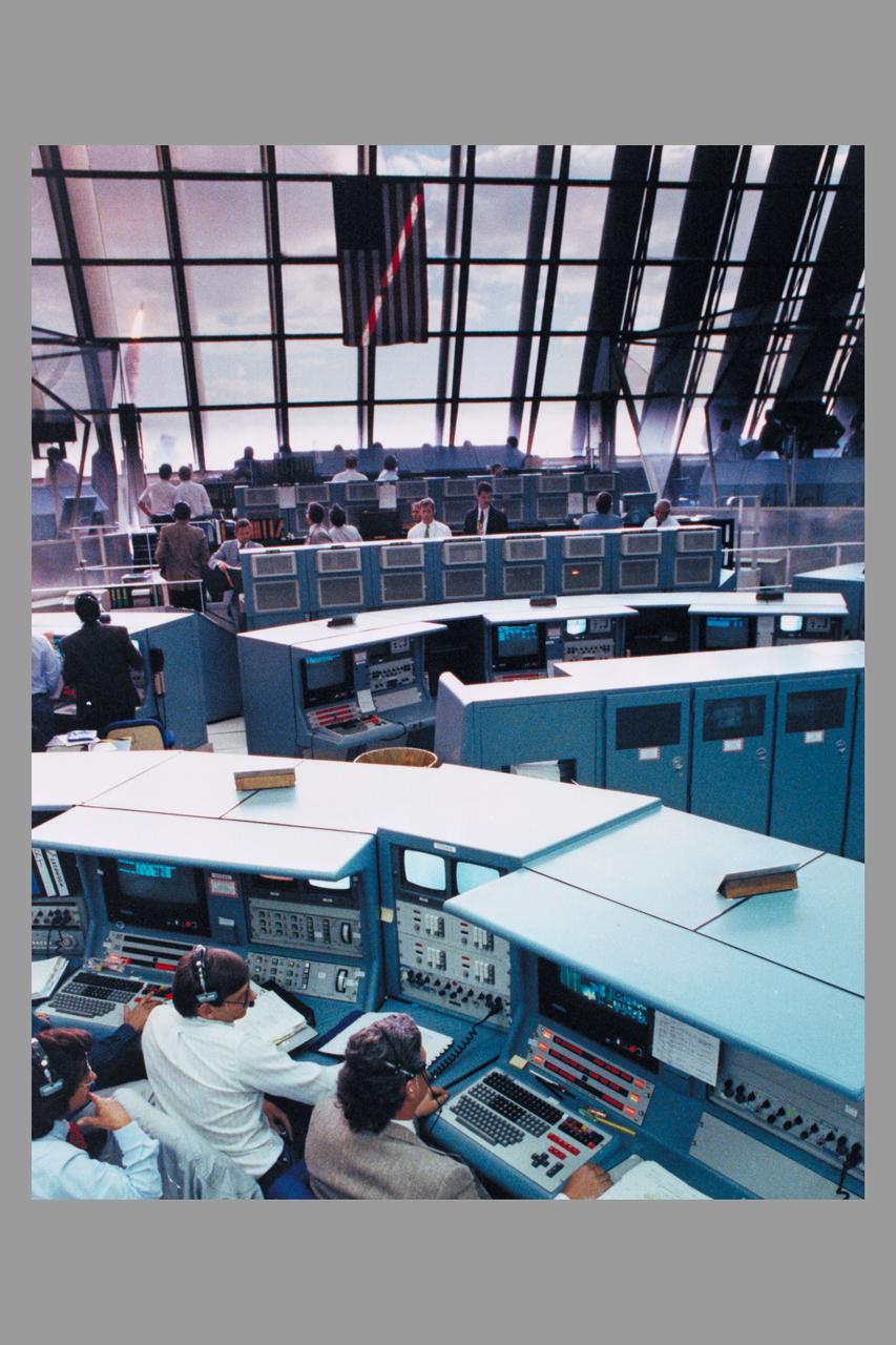 Kennedy Space Center Firing room during launch of Space Shuttle Discovery Hubble Space Telescope deployment Mission STS-31 (The Shuttle can be seen through window) (ref: KSC-90PC-626)