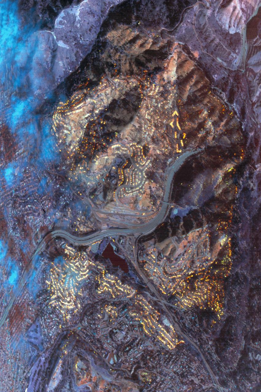 This data was acquired by the NASA C-130B Earth Resources Survey aircraft flying at 6,000 ft. mean sea level at 10:26 a. m. on October 21, 1991. The sensor used was the NS001 Thermatic Mapper Simulator, with a ground resolution of 4.6 meters (15ft). The image area is 4.7 x 3.2 km (2.9 x 2 mi.). The area covered is the Oakland Berkeley Hills near the Caldecott Tunnel (Upper right). Targets over 600 degrees centrigrade are shown as yellow in this composite of three infrared bands (11.6, 2.3, & 1.6 microns). A large condominium complex at the upper right is completely consumed. Areas already burned off sow as pale red. The blue clouds at left are condensed water vapor within the smoke plume, which blocks the infrared wavelength; the smoke itself is transparent.   Many hundreds of individual structures can be seen either actively burning or as heat of smouldering debris.