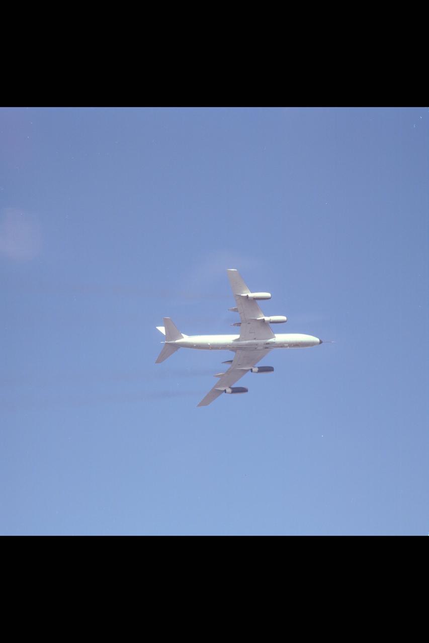 CV-990 (NASA-712) air to air view of underside of aircraft during banked turn during flight up California coastline