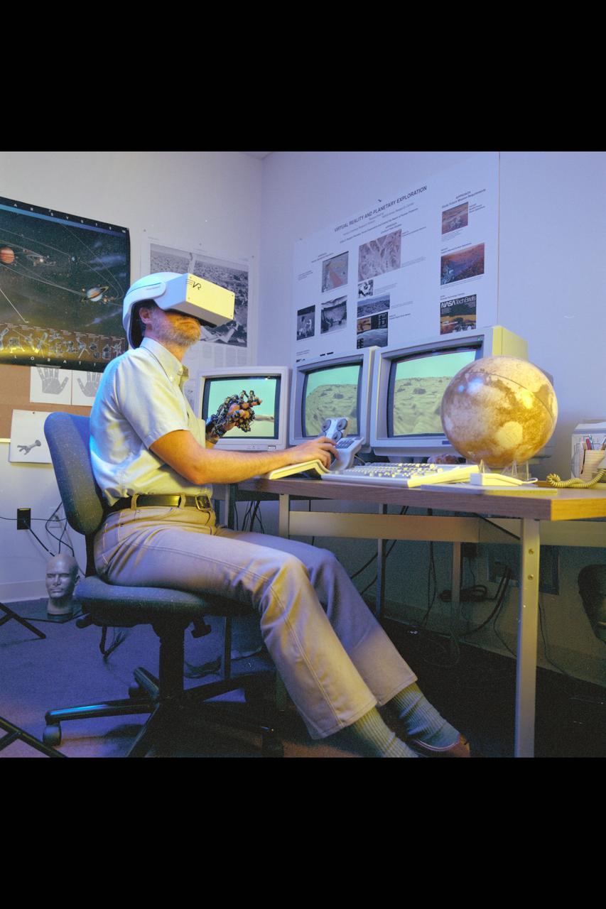 Virtual Environment Telepresence workstation, simulated Mars Exploration shows Lewis Hitchner with virtual helmet and  EXOS Dexterous interface (virtual hand)