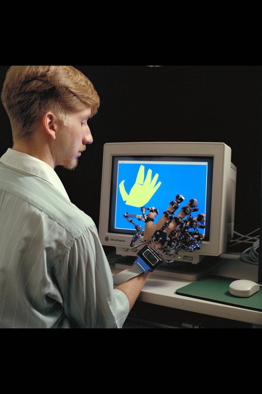 Virtual Environment Telepresence workstation, simulated Mars Exploration shows William Briggs with EXOS Dexterous interface (virtual hand)