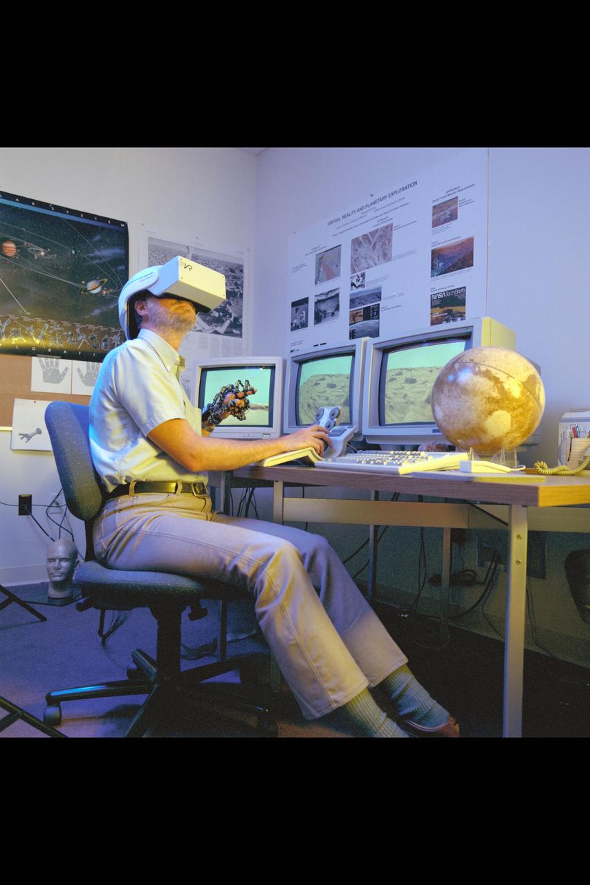 Virtual Environment Telepresence workstation, simulated Mars Exploration shows Lewis Hitchner with virtual helmet and  EXOS Dexterous interface (virtual hand)