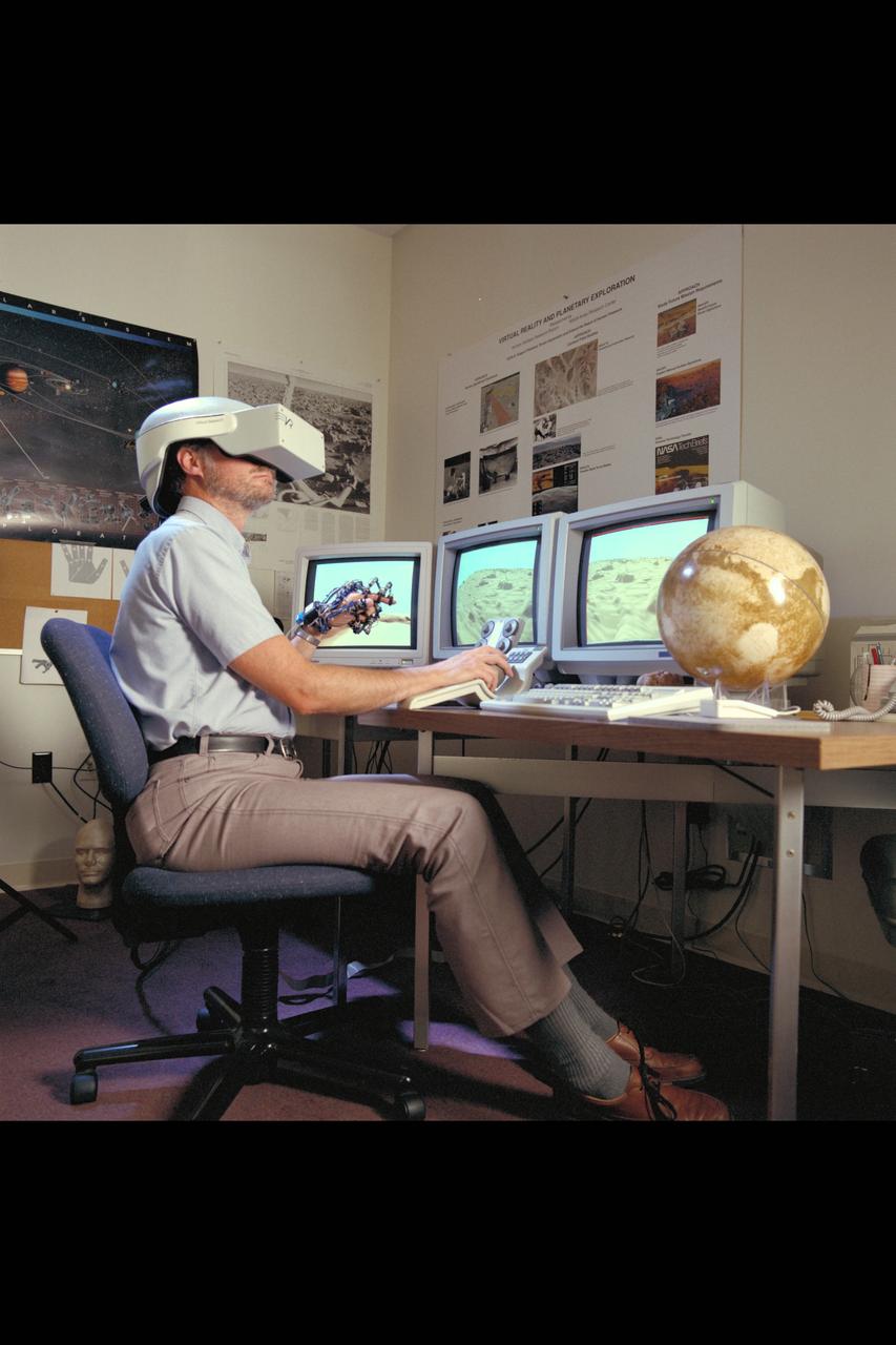 Virtual Environment Telepresence workstation, simulated Mars Exploration shows Lewis Hitchner with virtual helmet and  EXOS Dexterous interface (virtual hand)