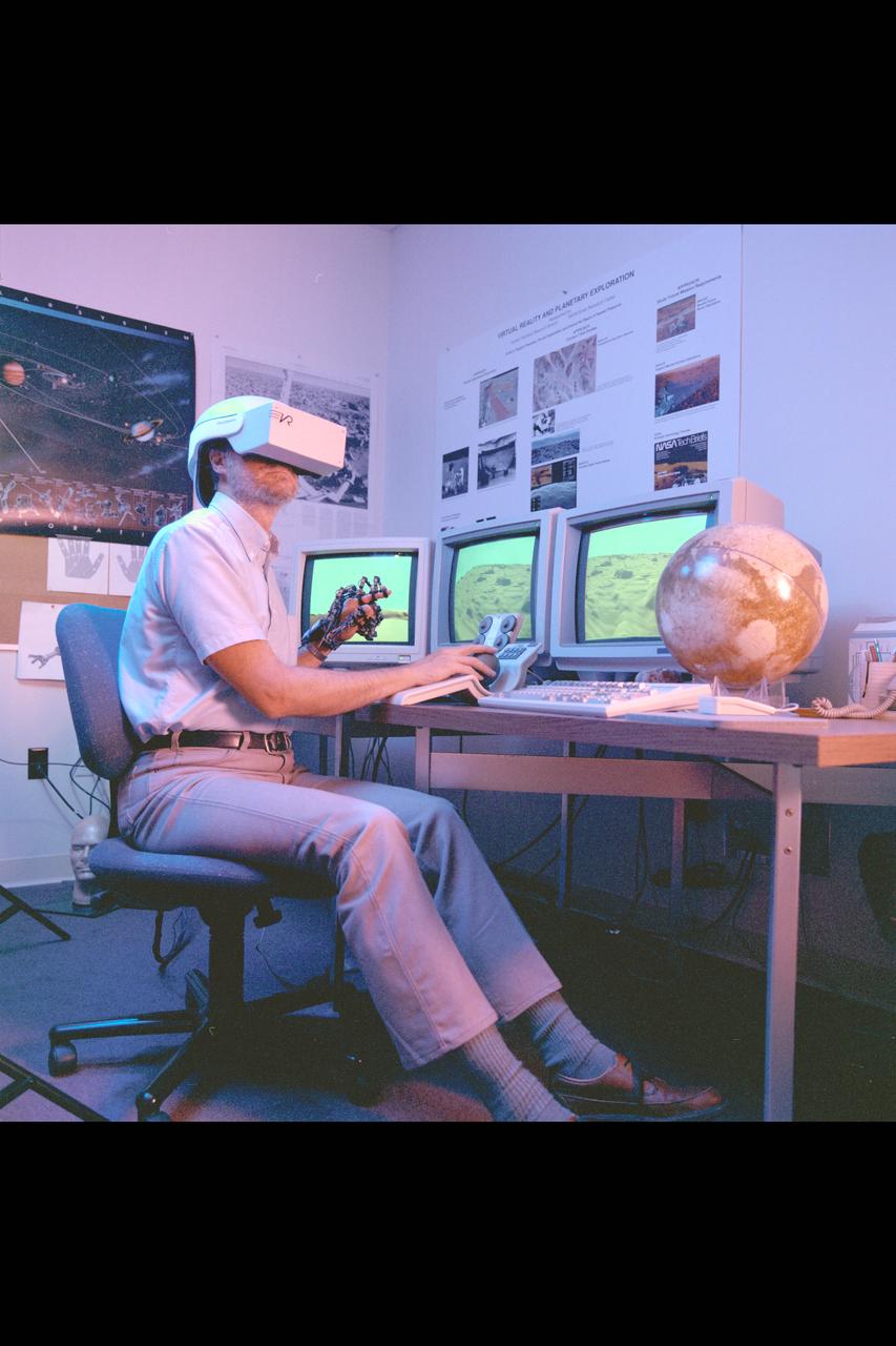 Virtual Environment Telepresence workstation, simulated Mars Exploration shows Lewis Hitchner with virtual helmet and  EXOS Dexterous interface (virtual hand)