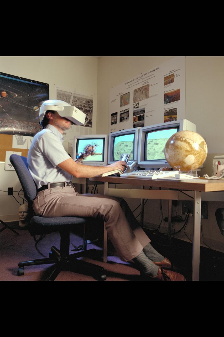 Virtual Environment Telepresence workstation, simulated Mars Exploration shows Lewis Hitchner with virtual helmet and  EXOS Dexterous interface (virtual hand)
