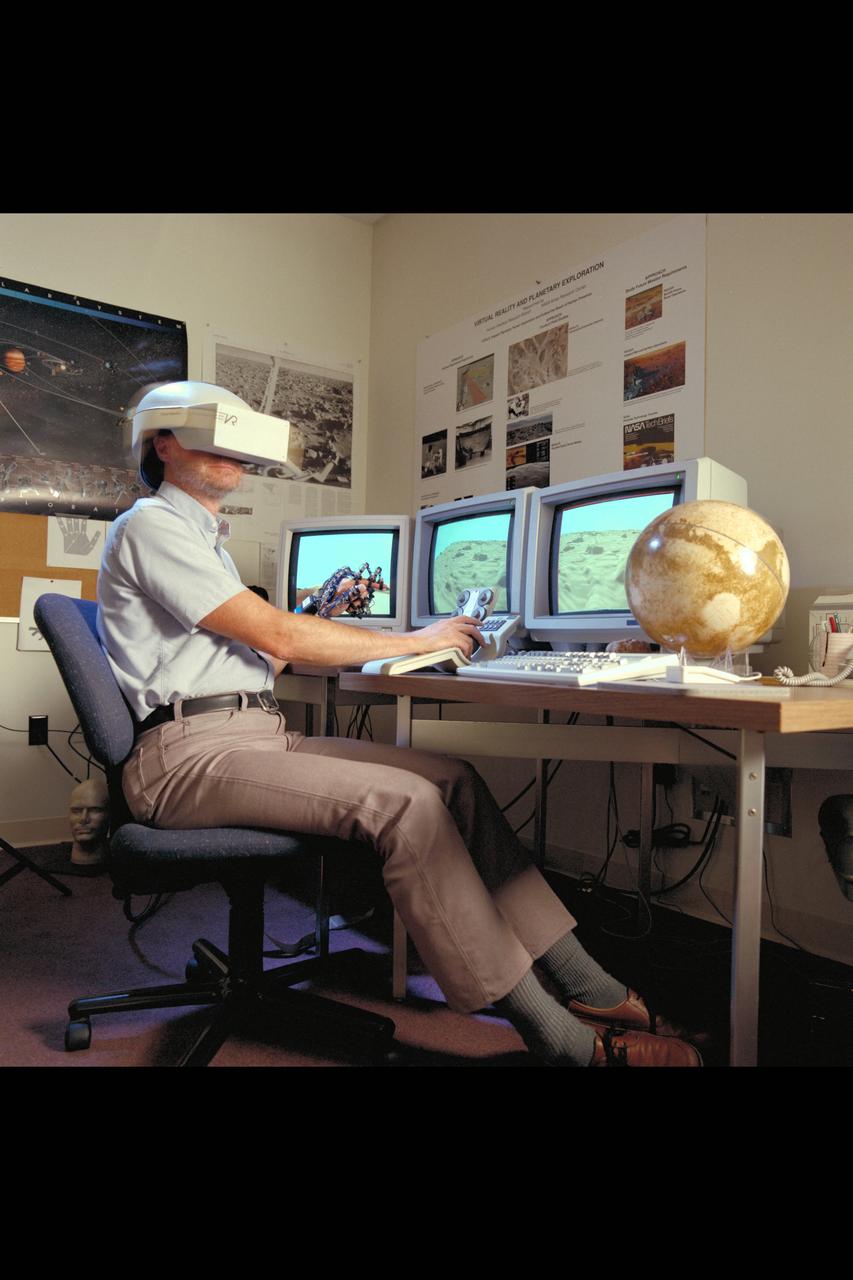 Virtual Environment Telepresence workstation, simulated Mars Exploration shows Lewis Hitchner with virtual helmet and  EXOS Dexterous interface (virtual hand)