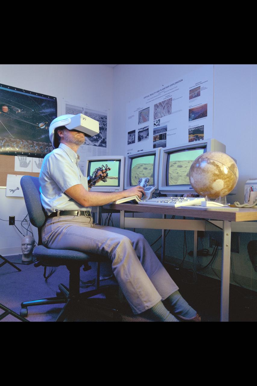 Virtual Environment Telepresence workstation, simulated Mars Exploration shows Lewis Hitchner with virtual helmet and  EXOS Dexterous interface (virtual hand)