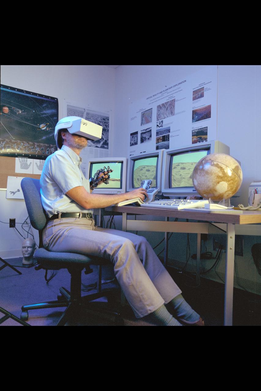 Virtual Environment Telepresence workstation, simulated Mars Exploration shows Lewis Hitchner with virtual helmet and  EXOS Dexterous interface (virtual hand)