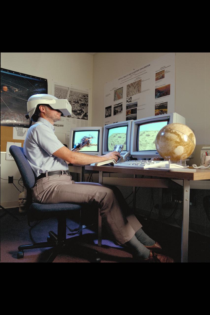 Virtual Environment Telepresence workstation, simulated Mars Exploration shows Lewis Hitchner with virtual helmet and  EXOS Dexterous interface (virtual hand)