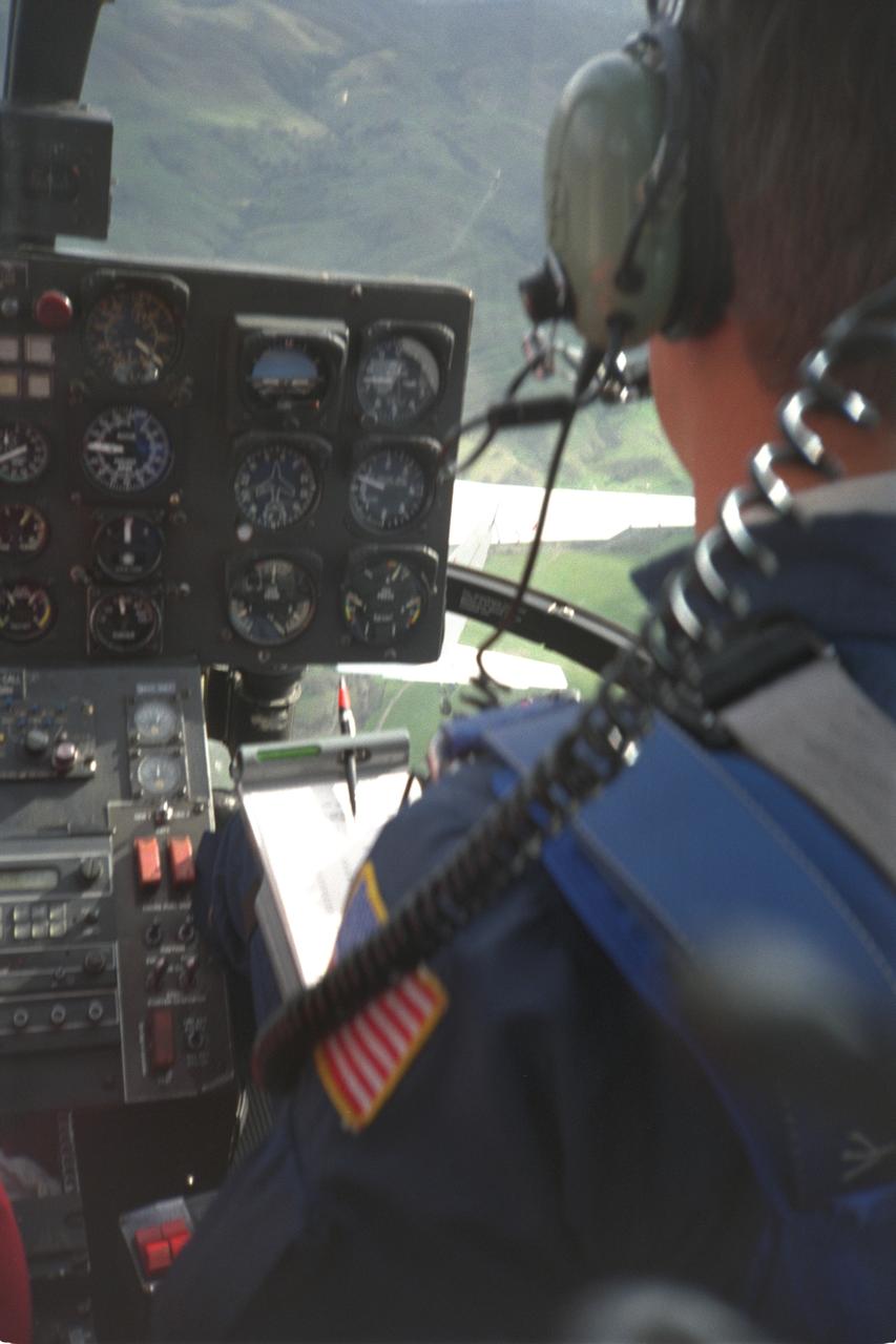 BO-105 helicopter pilot & cockpit during in flight rotorcraft acoustics program Distance Versus Noise Calibration over Livermore - Central Valley, CA. The YO-3A flying the acoustics test can just be seen through cockpit window.