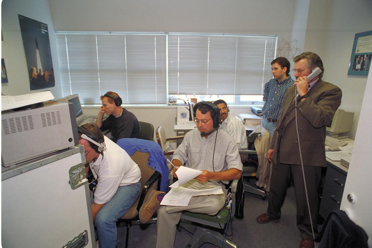 'Life from other Worlds' with McNair Middle School TROV robot explores under Antarctic ice - image video operations room and group (JIT) on left 2 unknows, center front Wade Sisler, behind Wade is Paul Langston, standing right David Maurantonio, unknown on phone.