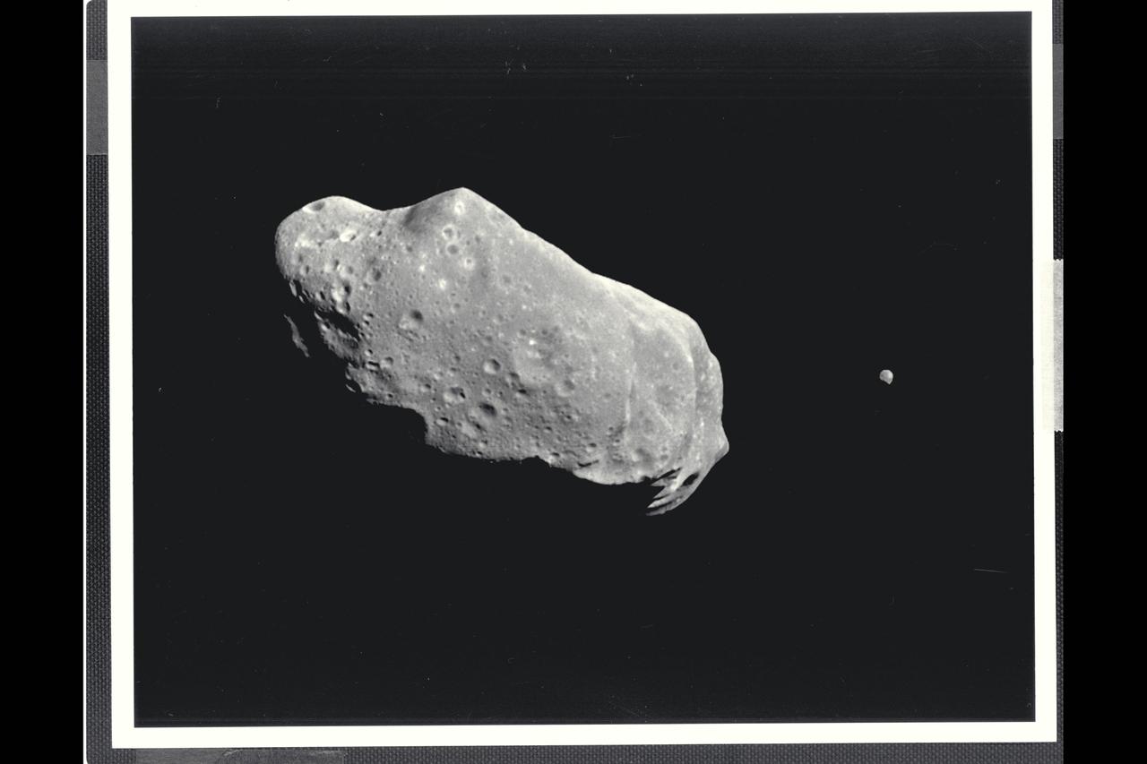 This image is the first full picture showing both asteroid 243 Ida and its newly discovered moon to be transmitted to Earth from NASA's Galileo spacecraft--the first conclusive evidence that natural satellites of asteroids exist. Ida is the large object to the left, about 56 kilometers (35 miles long). Ida's natural satellite is the small object to the right. This portrait was taken by Galileo's charge-coupled device (CCD) camera on August 28, 1993, about 14 minutes before the spacecraft's closest approach to the asteriod, from a range of 10,870 kilometers (6,755 miles). Ida is a heavily cratered, irregularly shaped asteroid in the main asteroid belt between Mars and Jupiter-- the 243rd asteroid to be discovered since the first one was found at the beginning of the 19th century. It is a member of a group of asteroids called the Koronis family. The small satellite, which is about 1.5 kilometers (1 mile) across in this view, has yet to be given a name by astronomers. It has been provisionally designated '1993 (243) 1' by the International Astronomical Union. (The numbers denote the year the picture was taken, the asteroid number and the fact that it is the first moon of Ida to be found.) ALthough the satellite appears to be 'next' to Ida it is actually slightly in the foreground, closer to the spacecraft than Ida. Combining this image with data from Galileo's near-infrared mapping spectrometer, the science team estimates that the object is about 100 kilometers (60 miles) away from the center of Ida. This image is one of a six-frame series taken through different color filters, this one in green. The spatial resolution in this image is about 100 meters (330 feet) per pixel. The Galileo spacecraft flew past Ida en route to its final destination, Jupiter, where it will go into orbit in December 1995. The Jet Propulsion Laboratory manages the galileo Project for NASA's Office of Space Science. (JPL ref. No. P-43731)
