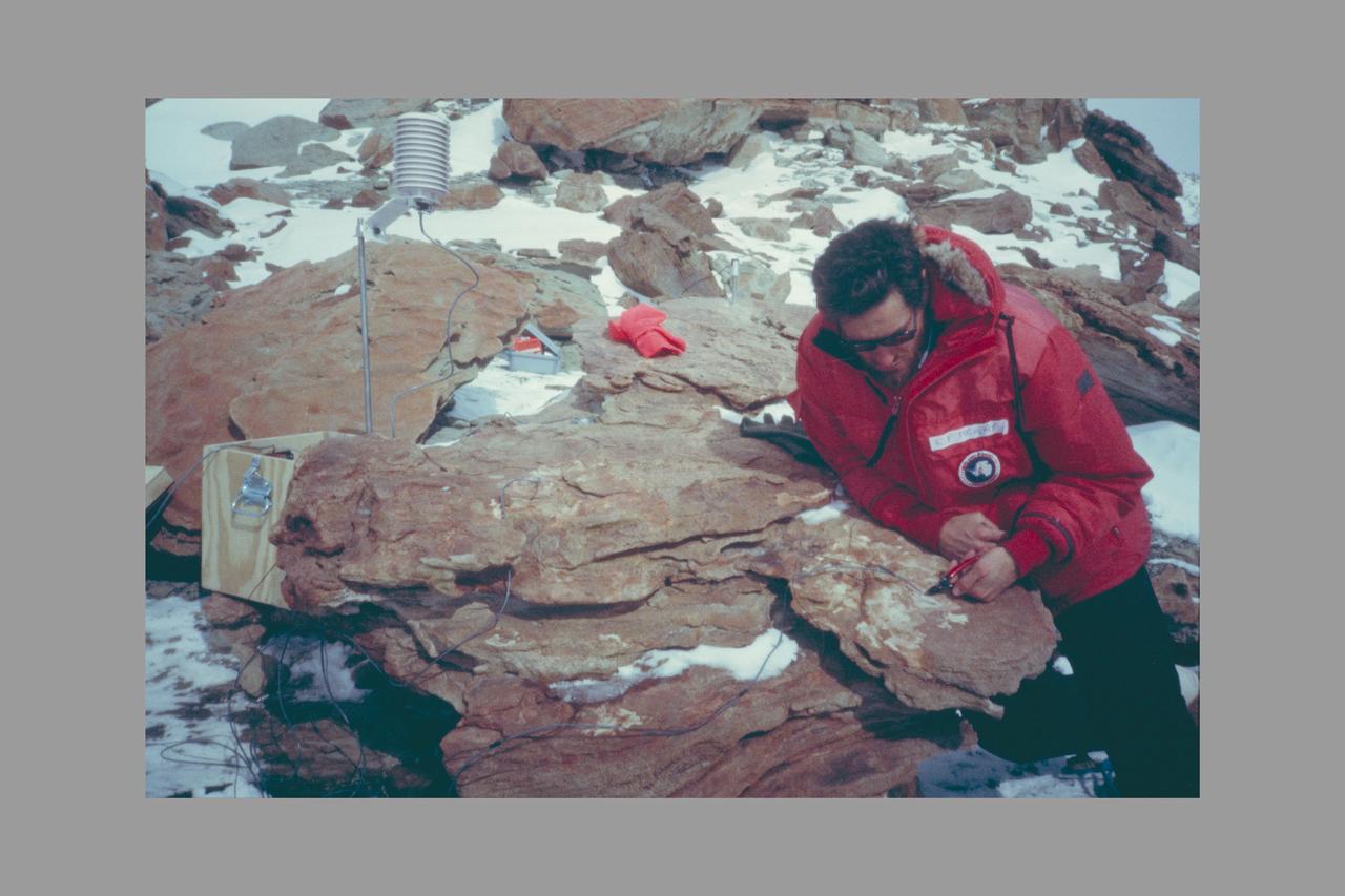 Dr. Chris McKay Deploying Environmental Monitoring Station in Colonized Sandstone, Dry Valleys, Antarctica.