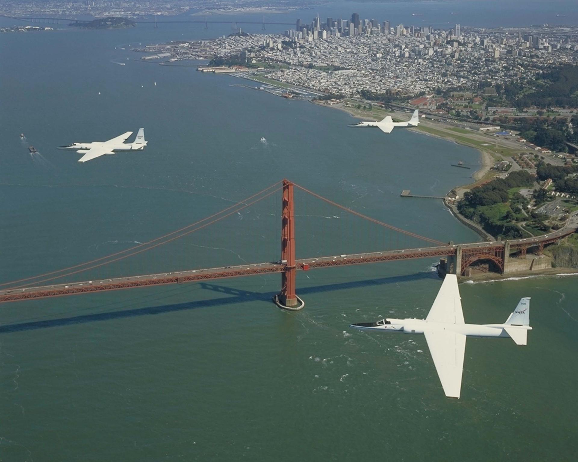 Three ER-2 aircraft fly in formation over the Golden Gate Bridge in California.