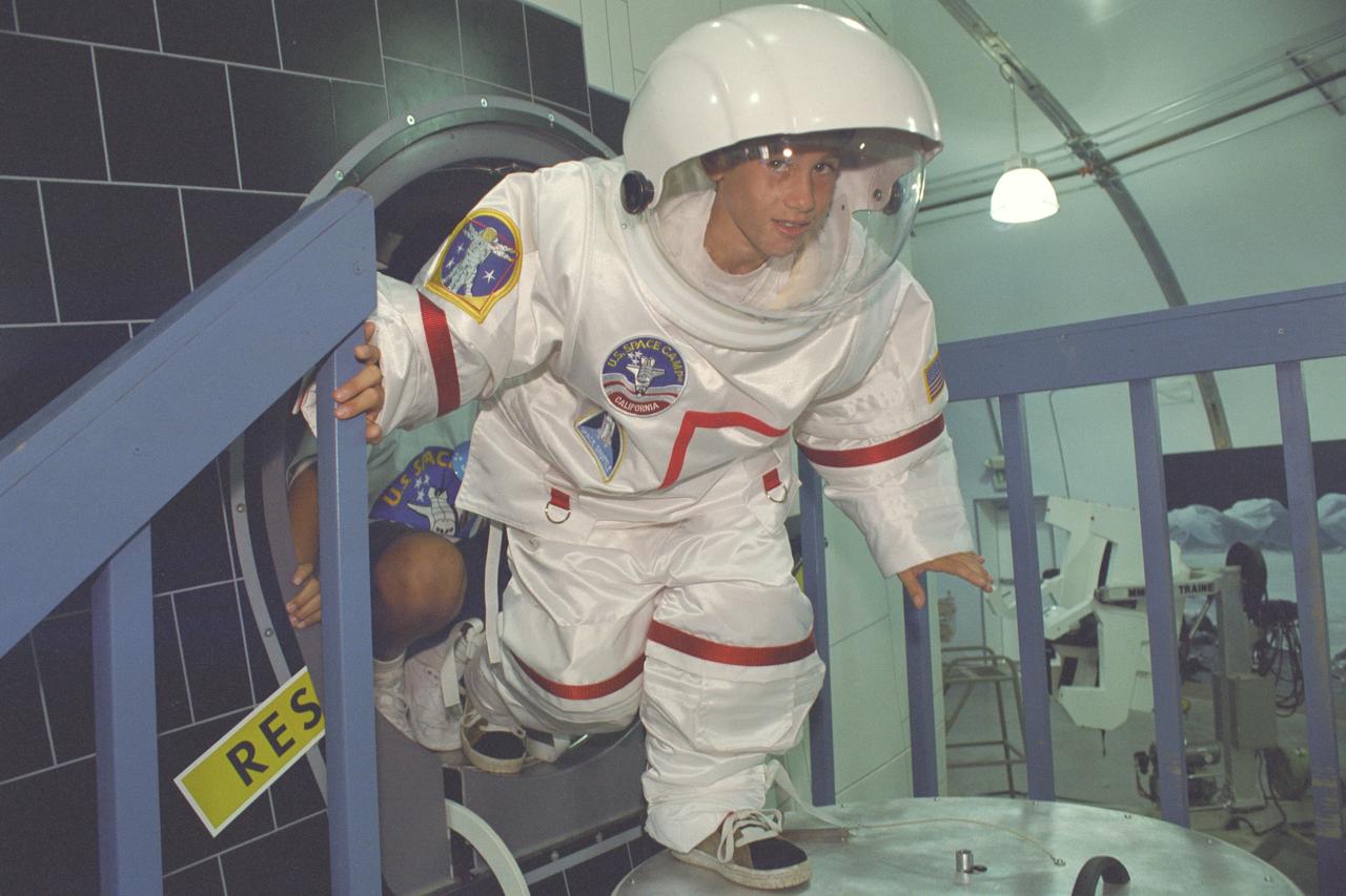 U.S. Space Camp California 'Day Camp' Grand Opening - student tries out space suit and shuttle mockup