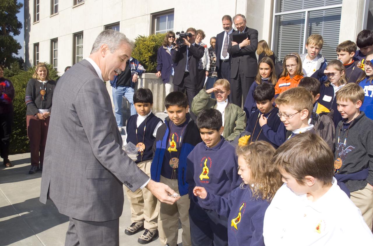NASA Administrator Sean O'Keefe comes to Ames for employee briefing and tour.  Here he welcomes JASON kids to NASA while handing out patches and pins.