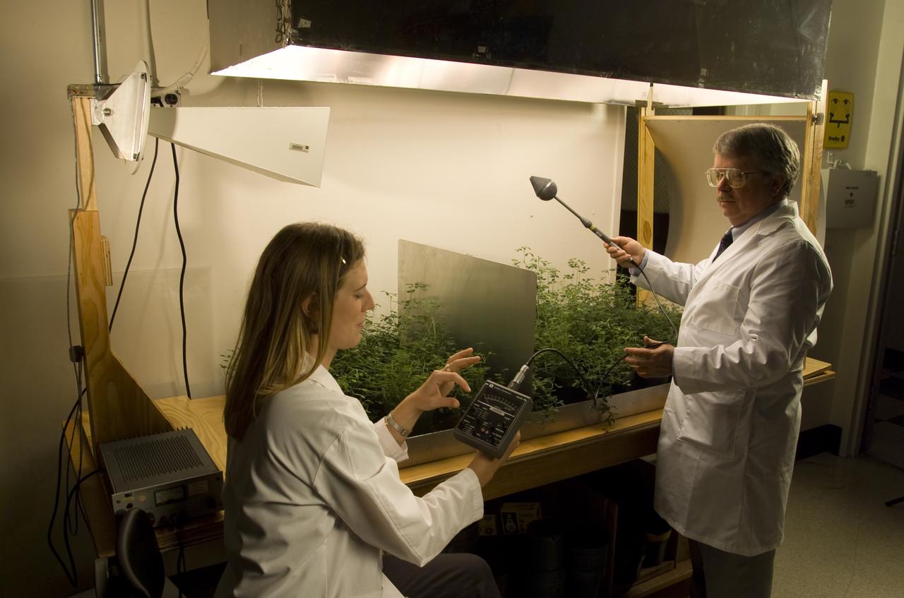Microvave effects on plant growth (alfalfa). Dana Rogoff, laboratory assistant, uses microwave intensity meter while Dr. Jay Skiles of NASA Ames Research Center, Moffett Field, Calif., holds probe.