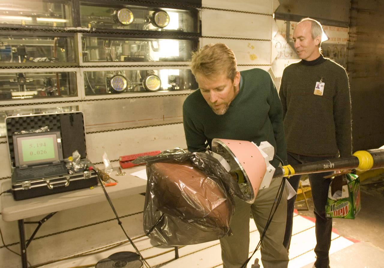CEV model with pressure sensitive paint (PSP) test 11-0148 in the 11ft Ames wind tunnel. Shown here with Bruce Stroms (l) and James Bell (r).