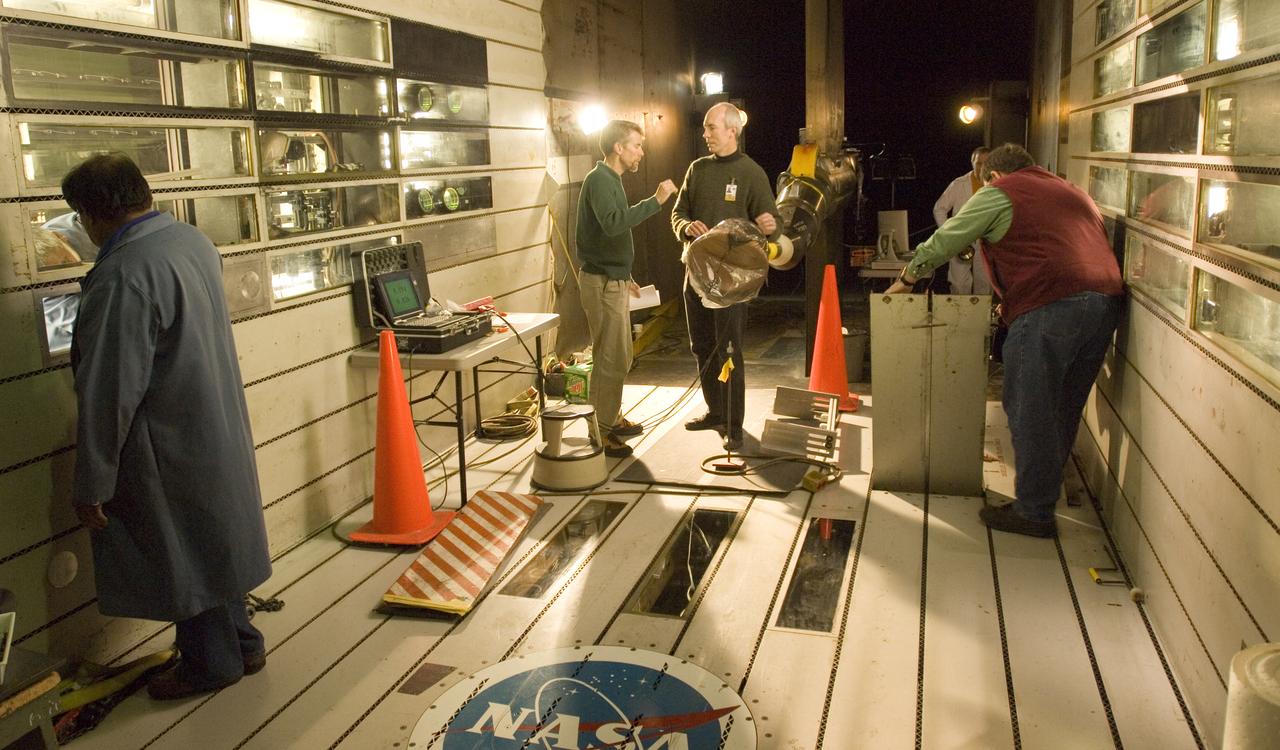 CEV model with pressure sensitive paint (PSP) test 11-0148 in the 11ft Ames wind tunnel. Shown here with Bruce Stroms (l) and James Bell (r) preparing model for test, Danny Ompac and Bill Moede also shown