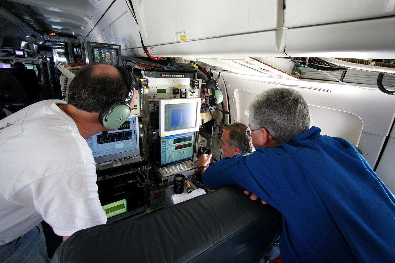 DC-8 NAMMA MISSION TO CAPE VERDE, AFRICA: Glenn Diskin (l) Bruce Anderson (c) & Ed Winstead (r) examine data on computer screens hooked up to two Langley Res. Ctr. experiments. The DLH (Diode Laser Hygometer) screen is on the left and one of the computer screens for the LARGE instrument package (Langley Aerosol Research Group Experiment) is on the right.