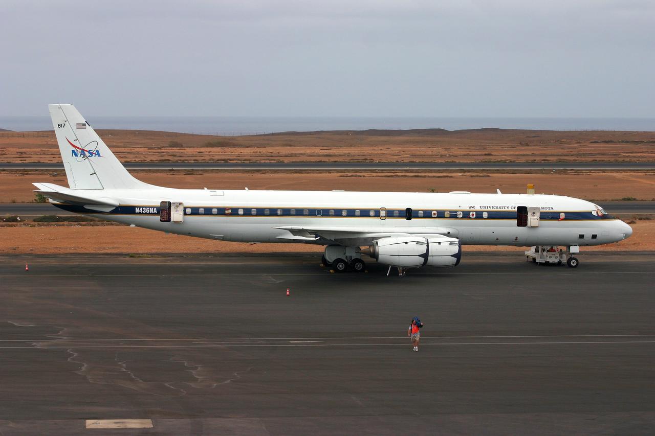 DC-8 NAMMA MISSION TO CAPE VERDE, AFRICA: NASA'S DC-8 parked on ramp of Sal Island's Amilcar Cabral International Airport in the Cape Verde Islands. NASA Ames photographer Eric James is seen in the foreground carrying equipment off the airplane.