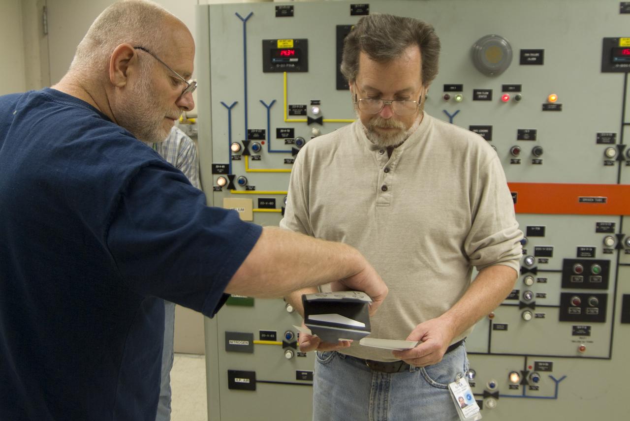 CEV (Crew Escape Vehicle) capsule Balistic Range testing to examine static and dynamic stability characteristics  (at the Hypervelocity Free-Flight Facility) HFF - Don Holt (L) & Don Bowling (r) in control room examining poloroids