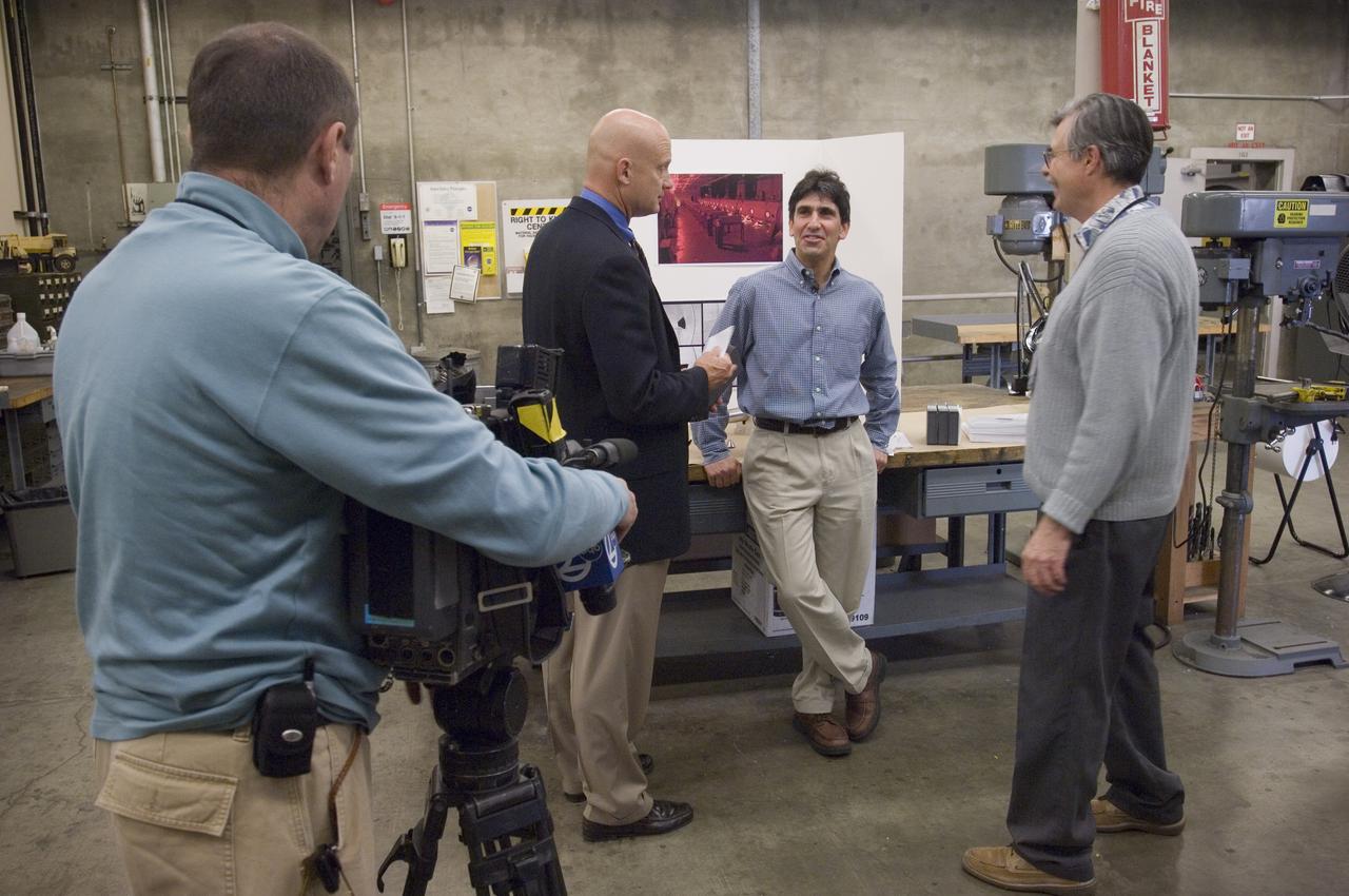 Ames holds a Media Day at the Hypervelocity Free Flight facility where Ames is conducting high-speed tests of small models of the agency's new Orion CEV  to learn about stability during flight. The hypervelocity test facility uses a gun to shoot Orion models between 0.5 and l.5 inches (1.25 - 3.75 centimeters in diameter. The facility can conduct experiments with speeds up to 19,000 miles per hour (30,400 kilometers per hour) - ABC Camerman in forground, Wayne Freedman ABC reporter, Jeff Brown (Ames-ASA), John Bluck (AMES PAO)
