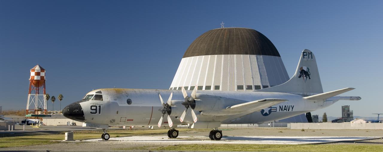 Ames and Moffett Field (MFA) historical sites and memorials Navy Lockheed P-3 Orion Long Range Antisubmarine Partol Aircraft on display in front of MFA Bldg 158 Flgiht Ops (tower) with monuments