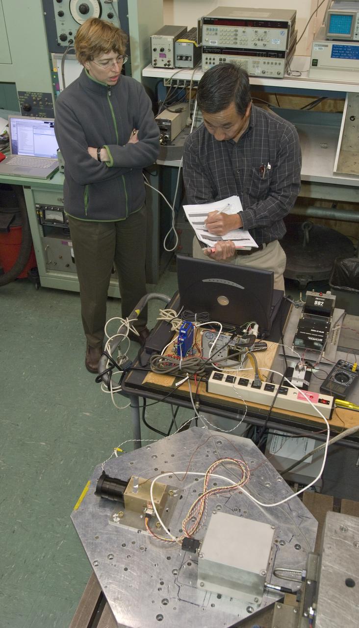 Lunar CRater Observation and Sensing Satellite (LCROSS) and P.I. at NASA Ames Research Center - Total Luminance Photometer shake test in N-244 (EEL) : Metal shake table close up. Shows two units bolted on. The left one is the lens, sensor electronics and photometer sensor. The right is the digital electronics unit for the instrument.  The two units, along with their cabling is one of the LCROSS science insruments.