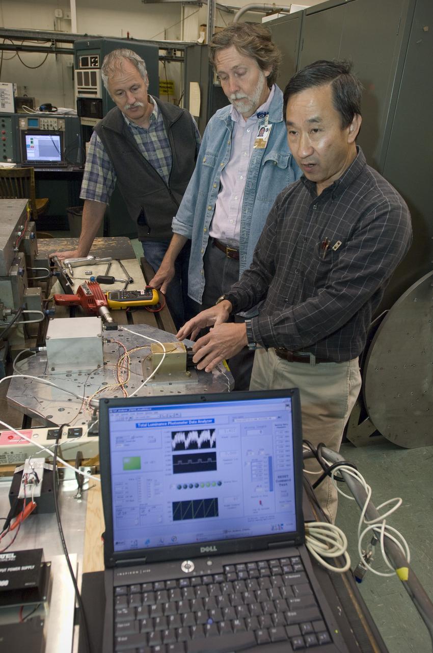 Lunar CRater Observation and Sensing Satellite (LCROSS) and P.I. at NASA Ames Research Center  - Total Luminance Photometer lens and electronics units on shake table in N-2444 EEL Laboratory: Gi Kojima, Dana Lynch and Lynn Hofland check electronics. Data analyzer is the foreground.