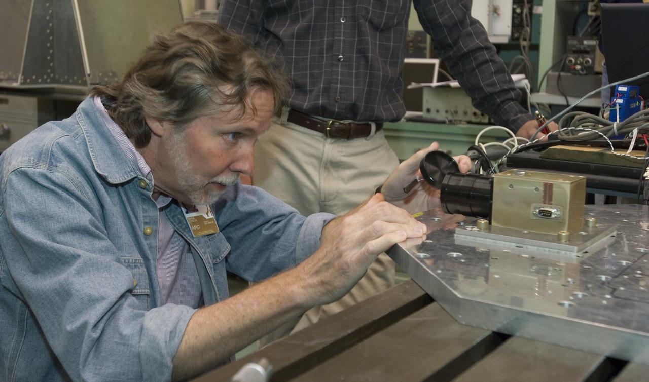 Lunar CRater Observation and Sensing Satellite (LCROSS) and P.I. at NASA Ames Research Center Dana Lynch looking at Total Luminance Photometer lens durnig shake testing in the EEL laboratory.