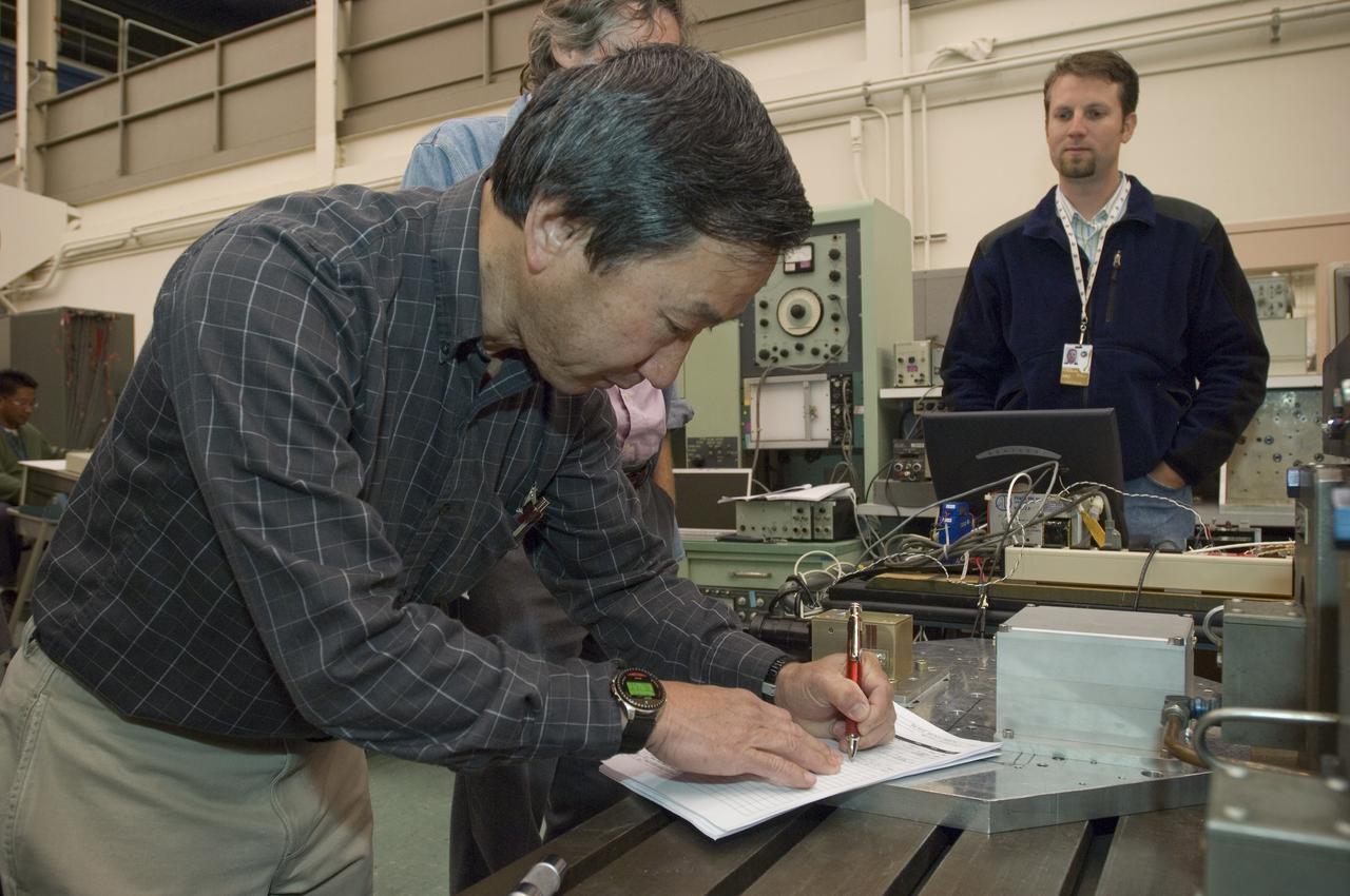 Lunar CRater Observation and Sensing Satellite (LCROSS) and P.I. at NASA Ames Research Center - Total Luminance Photometer shake test in N-244 EEL Laboratory; Gi Kojima foreground and Damon Flansbury in backgroud.