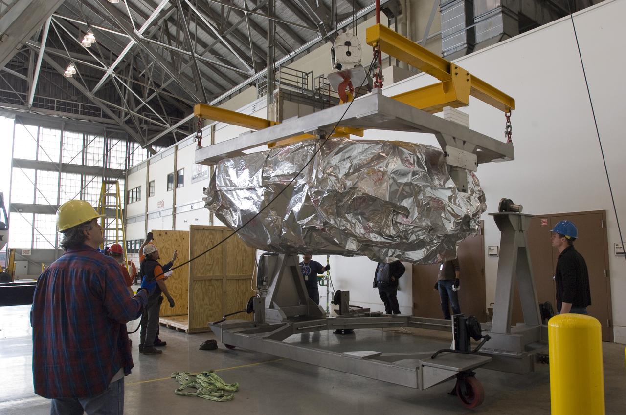 SOFIA (Stratospheric Observatory for Infrared Astronomy) primary mirror being moved into N-211, readied and move into the Ames Vacuum Chamber for the coating process.