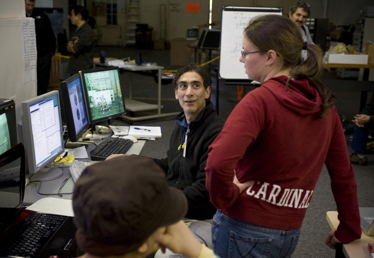 Lunar Atmosphere and Dust Environment Explorer (LADEE) Project in Building 45 Modular Common Spacecraft Bus as a hover test vehicle, here they are installing spacecraft electronics & payloads.  Whith Doug Forman (seated) and Eleanor Crane (standing)