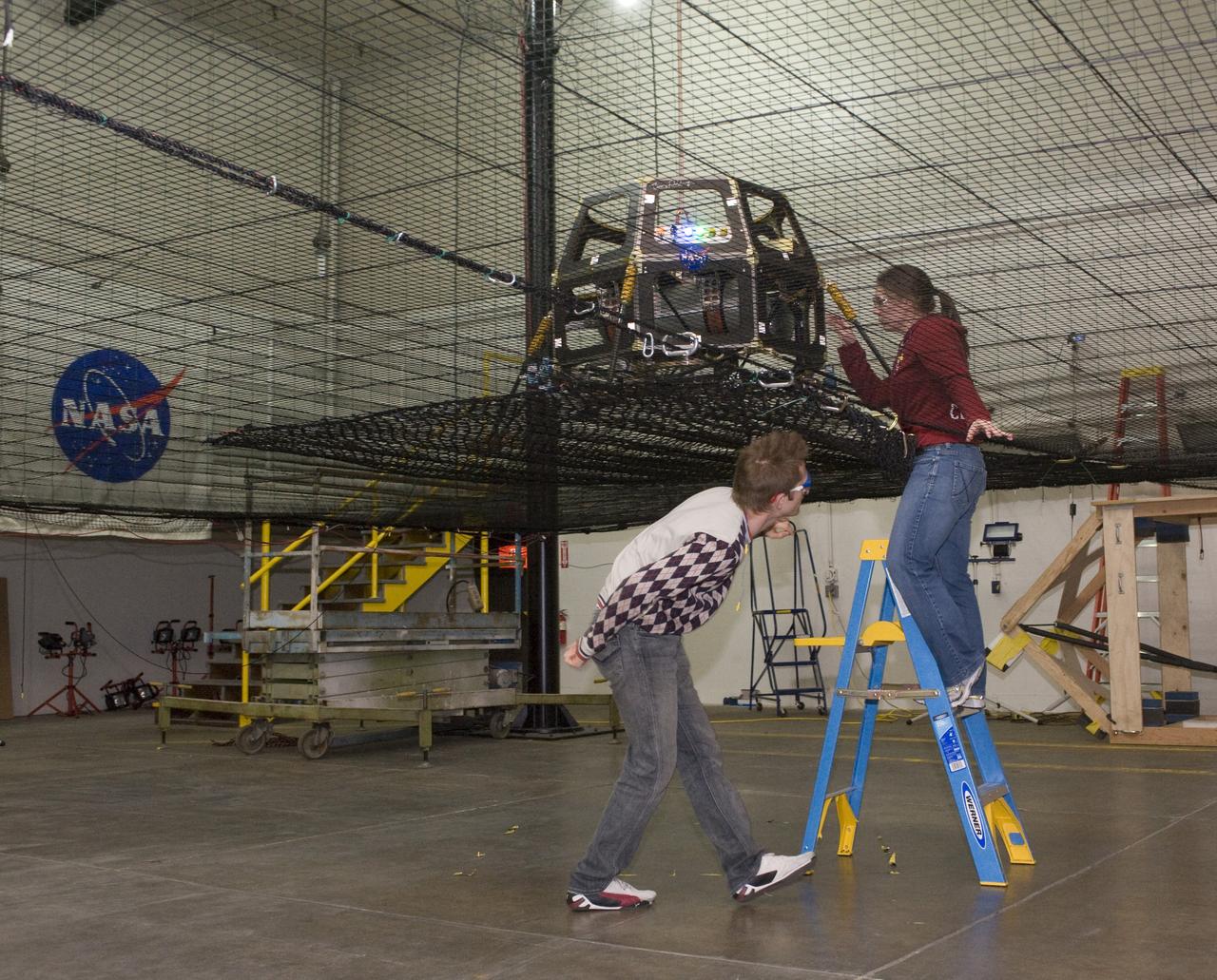 Lunar Atmosphere and Dust Environment Explorer (LADEE) Project in Building 45 Modular Common Spacecraft Bus as a hover test vehicle, here they are installing spacecraft electronics & payloads.  with Chris Boshuizen (in plaid) and Eleanor Crane (in red)