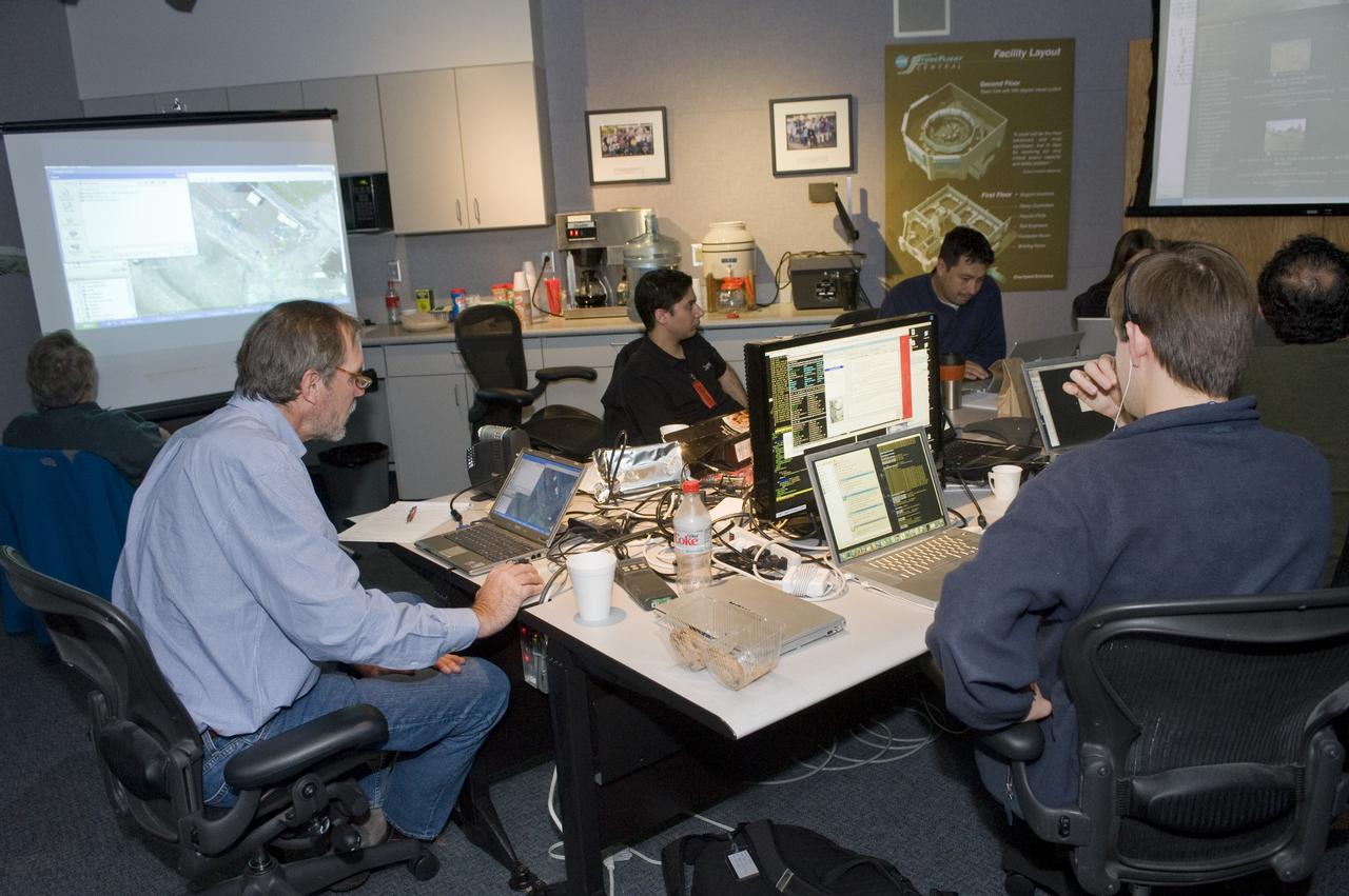 K-10 (red) plaentary rover at Marscape (Ames Mars Yard): with prototype flight control team remotely operating K-10 'Red' from  Ames Future Flight Centeral (FFC) Simulator,  L-R; Kip Hodges, Mark Helper, Marwan Hussein, Pascal Lee, Melissa Rice, Trey Smith, David Lees