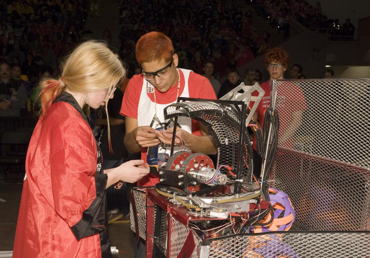 FIRST Robotics Competition  'Lunacy'  hosted by NASA at San Jose State University Event Center. For Inspiration and Recognition of Science and Technology let the games begin. Ragin' C-Biscuits of San Ramon Valley High team #1280 and the Hawaiian Kids team #359 look over a problem bot.