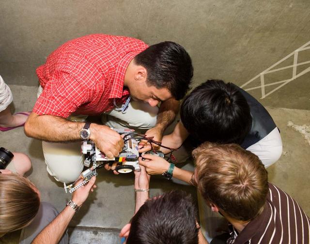 International Space University (ISU - 2009) students participated in a Robotic Competition at NASA'A Ames Research Center, Moffett Field, Calif. This panel featured astronauts from four different space agencies with different areas of expertice and diverse perspectives. Konstantin Anonakopoulos, ISU SSP09 student makes last minute adjustments to a robot with his team members before the competition begins,