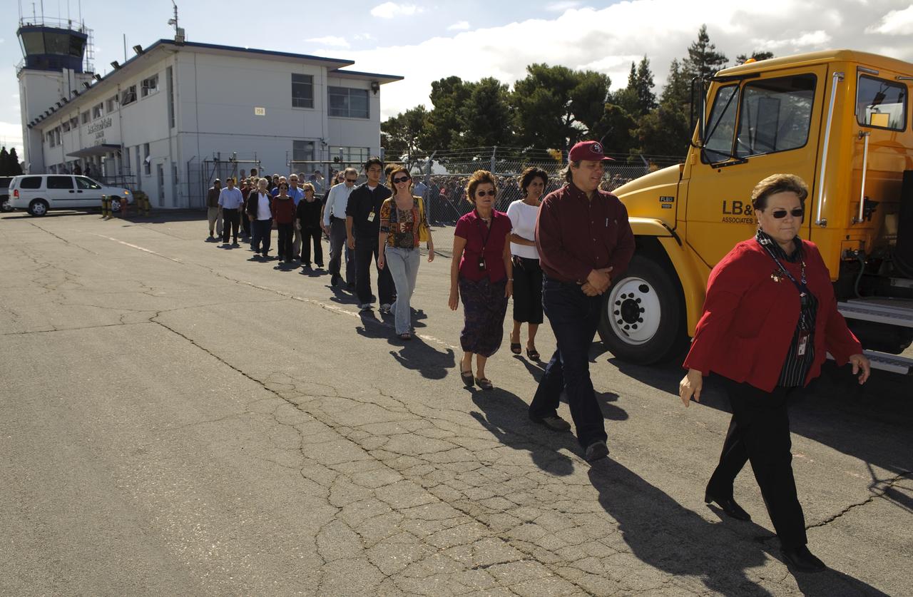 Ames 70_year picture day on Flight line. Carolyn Garcia leads the the staff to their places in the line to keep the numbers uniform.