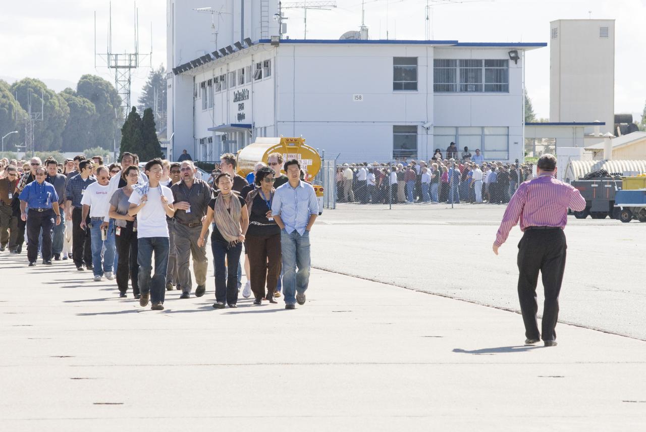 Ames 70_year picture day on Flight line. David Morse leads the the staff to their places in the line to keep the numbers uniform.