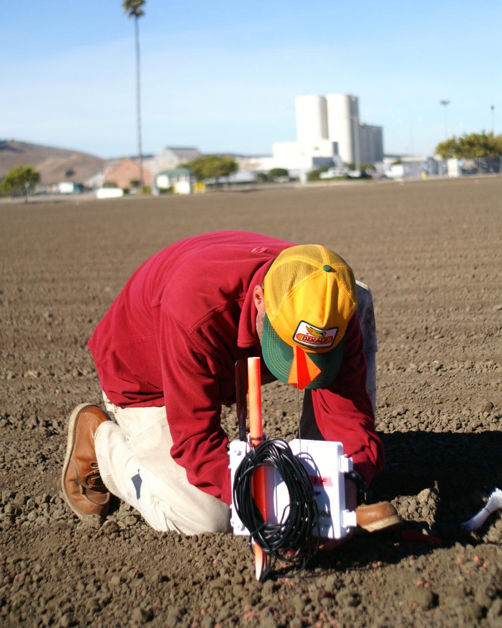 Wireless crop water monitoring project: Dr. Chris Lund, a scientist at the California State University Monterey Bay who is working on the NASA project at NASA Ames installs soil mositure probes in an agricultural field. The soil mositure measurements will be used to assist in interpretation of the satelite estimates of crop water deamand. Image of courtesy of Forrest S. Melton