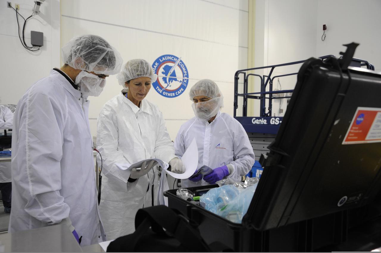 From left, Giovanni Minelli with the NASA's Ames Research Center; Center: Kitty Sedam with Aerospace Corp.; and Charlie Friedericks with Ames inspect the packing list and instructions for the Ames-managed O/OREOS and NanoSail-D from NASA's Marshall Space Flgith Center nano satellites at Kodiak Launch Complex, Alaska . Image credit: U.S. Air Force/Lou Hernandez