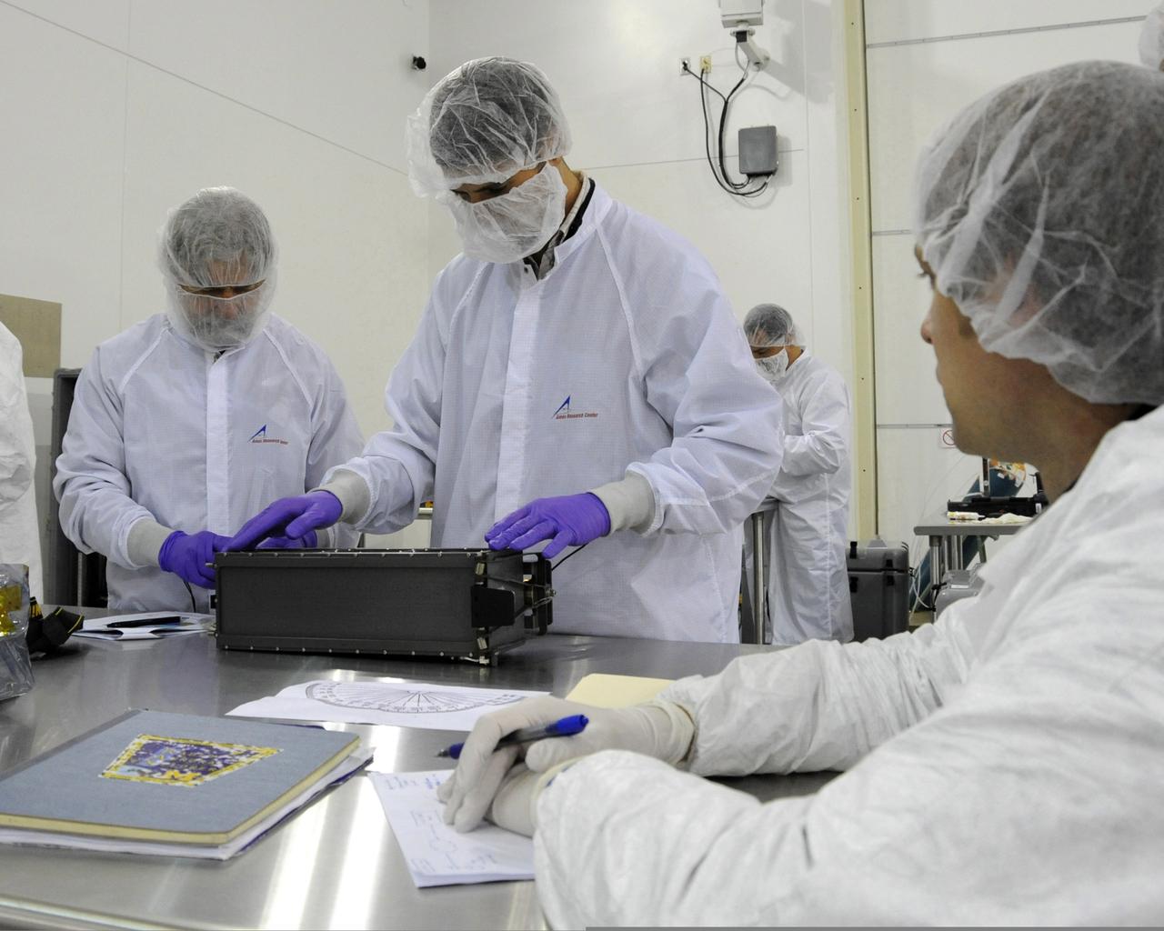 From left, Charlie Friedericks and Giovanni Minelli with the NASA's Ames Research Center; inspect the Ames-managed O/OREOS nana satellite at Kodiak Launch Complex on Kodiak Island, Alaska. in advance of the satellite's planned launch into orbit. Image credit: U.S. Air Force/Lou Hernandez